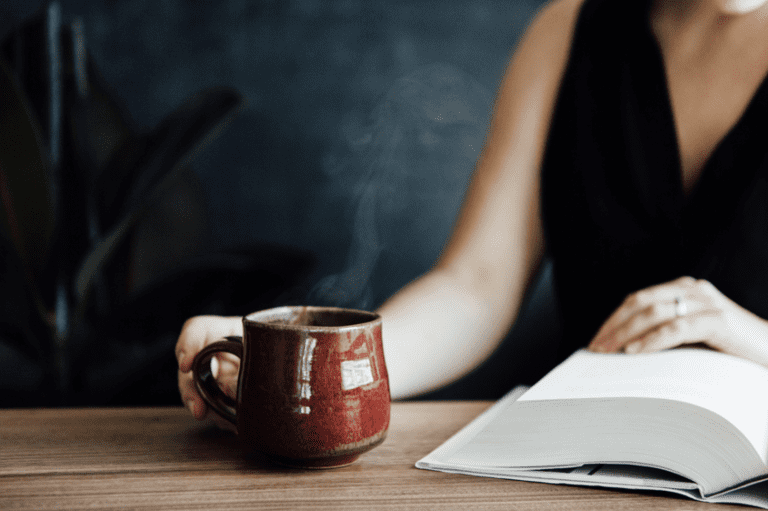 someone reading a book while enjoying a cup of coffee
